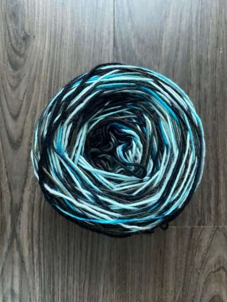 Caked skein of blue and black yarn